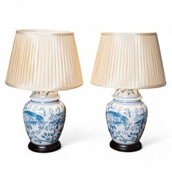 Pair of table lamps of baluster form, decorated with exotic birds up fruiting trees, on ha...