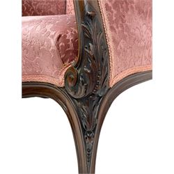 Late 19th century carved walnut framed armchair, the upper spandrels pierced and carved with curled acanthus leaves, upholstered in pink foliate pattern fabric, acanthus leaf carved and scrolled arm facias terminating to cabriole supports, leaf carved terminals 