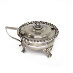 George IV silver mustard pot and cover, of circular bellied form, with oblique gadrooned r...