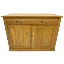 Contemporary light oak sideboard desk, rectangular top with full length drawer, hinged front panel revealing pull-out keyboard tray, over two panelled doors enclosing an assortment of shelves and compartments with cable management holes, on plinth base