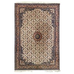 Indo-Persian Herati design ivory ground rug, central medallion on a field of repeating flo...