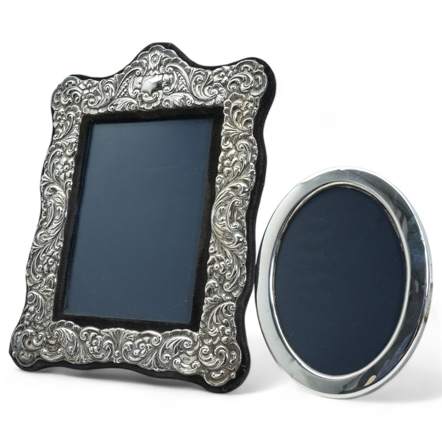 Embossed silver photograph frame, aperture 17cm x 12xm Sheffield 1984, Maker Laurence R Watson & Co  and an oval silver frame 13.5cm x 9.5cm  (2)