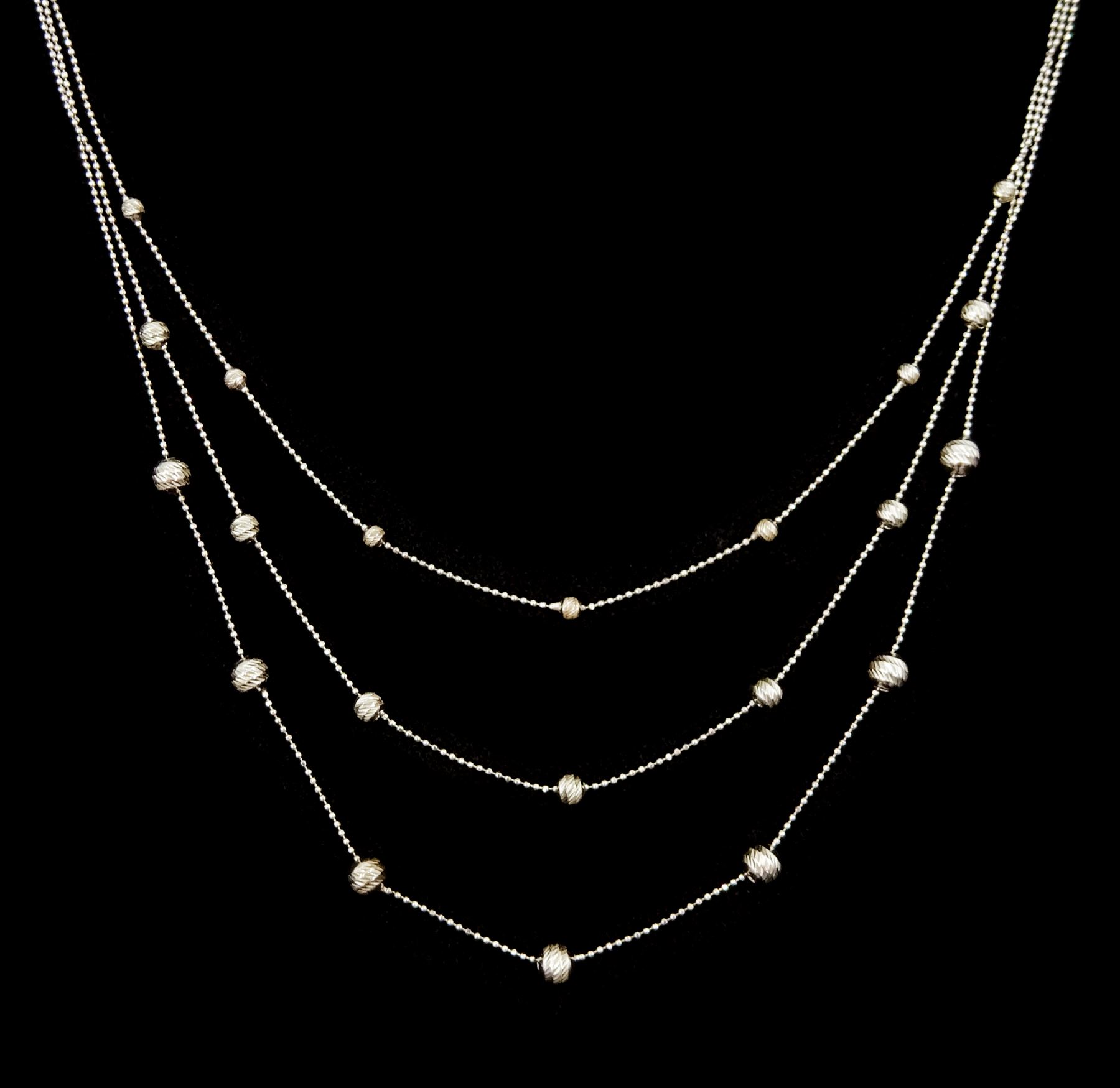 18ct white gold three strand bead necklace, stamped 750