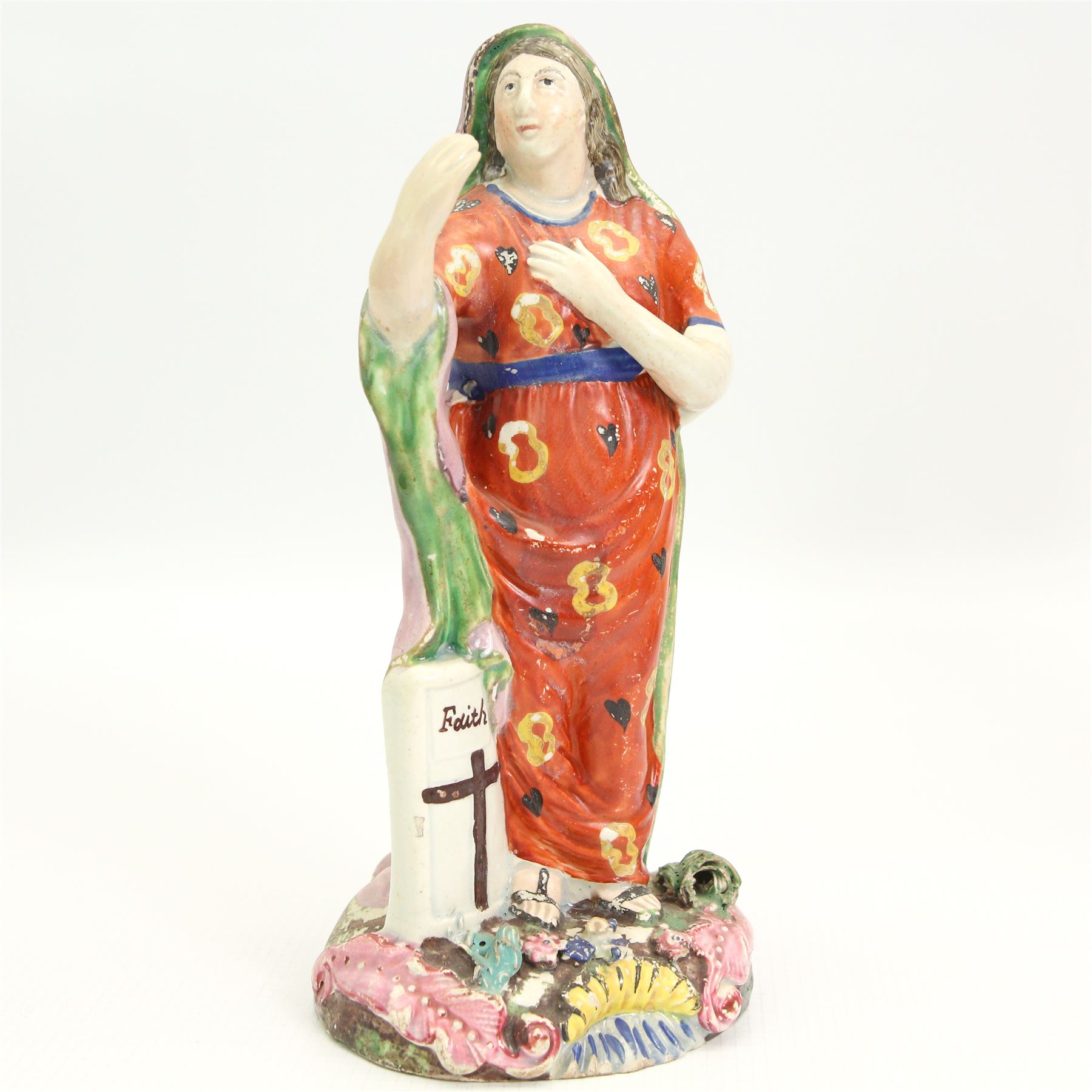 Three early 19th century Staffordshire Pearlware figures depicting Faith, Hope and Charity, Faith standing next to a shield bearing a cross, on an oval encrusted and moulded base H20cm, Charity stood holding a child and another by her side and Hope standing with an anchor, both on square bases (3)