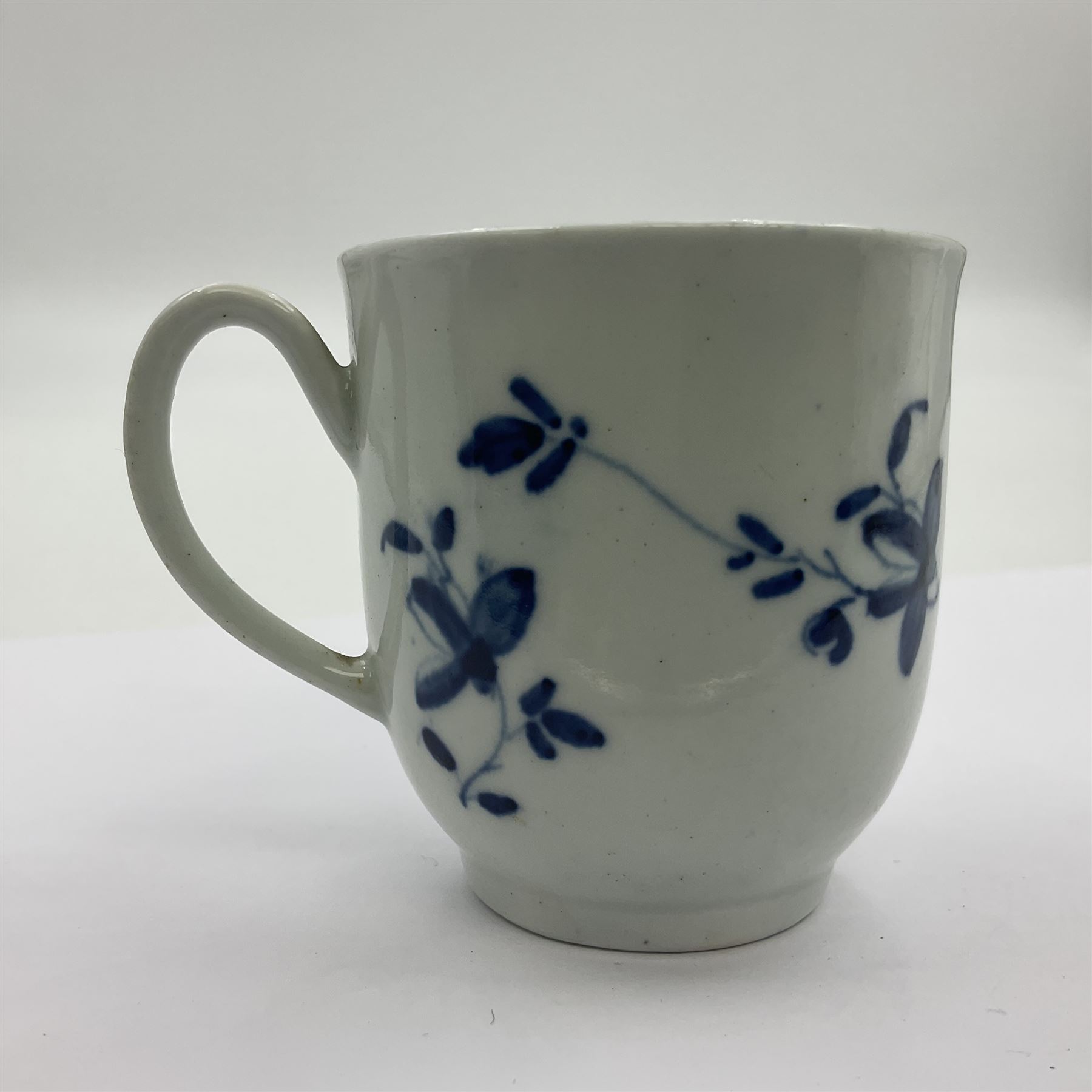 Two 18th century Worcester porcelain coffee cups, the first example decorated in the Plantation pattern, circa 1754, the second decorated in the Mansfield pattern, circa 1760, with workman's mark beneath, each approximately H5.5cm