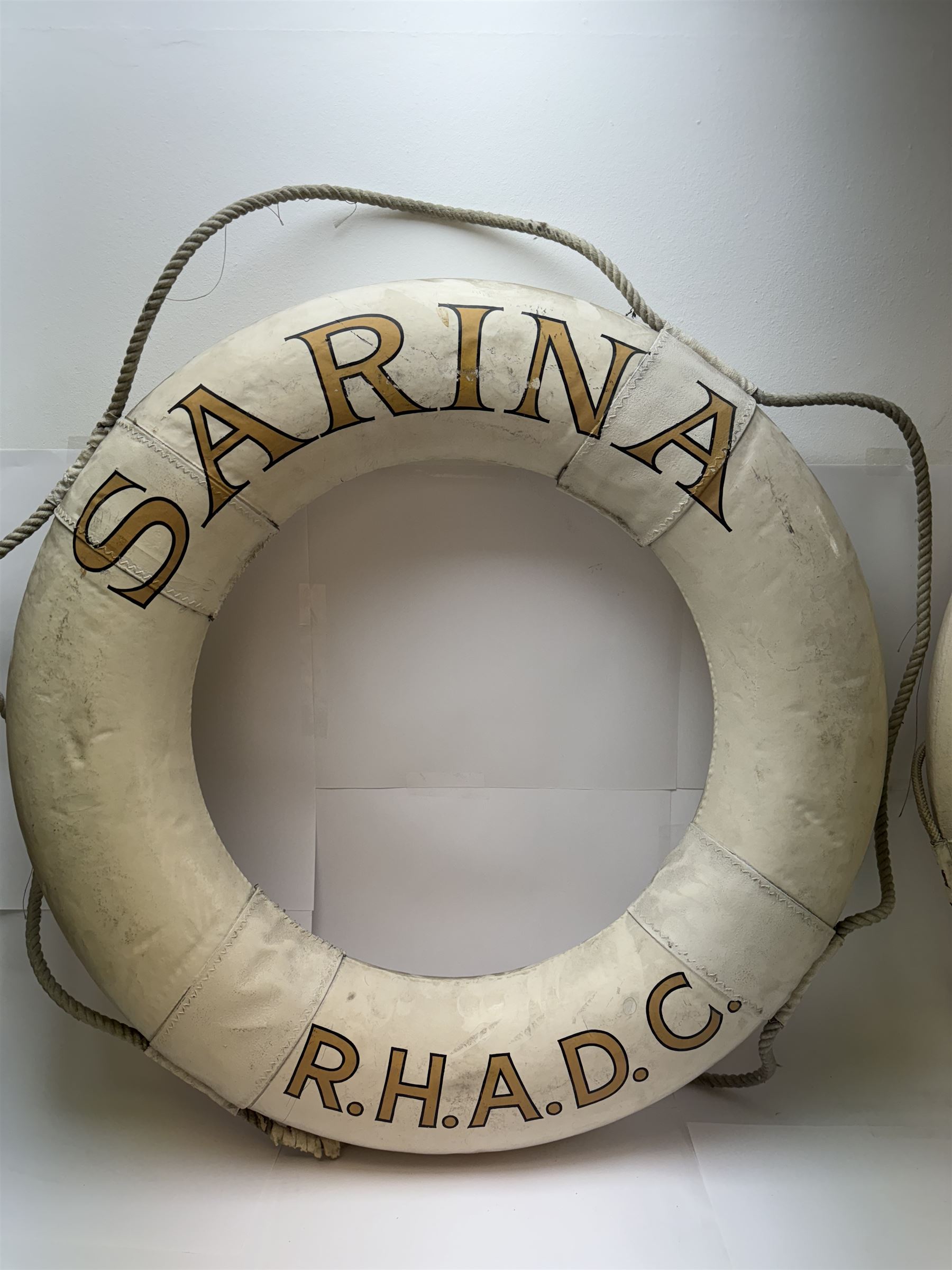 Four mid 20th century yacht lifebuoys, each painted in gold and black lettering 'Sarina R.H.A.D.C', upon a white ground, D68cm