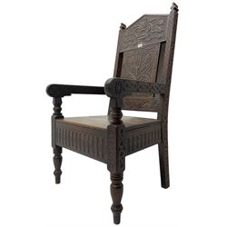 17th century design oak wainscot chair, the back profusely carved with scrolling foliate motifs, the arms carved with repeating guilloche decoration over an arcade apron and turned supports