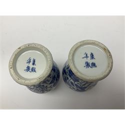 Pair of Chinese blue and white vases, of squat baluster form, each depicting figures holding a ginger jar, with four character Kangxi mark beneath, H13.5cm