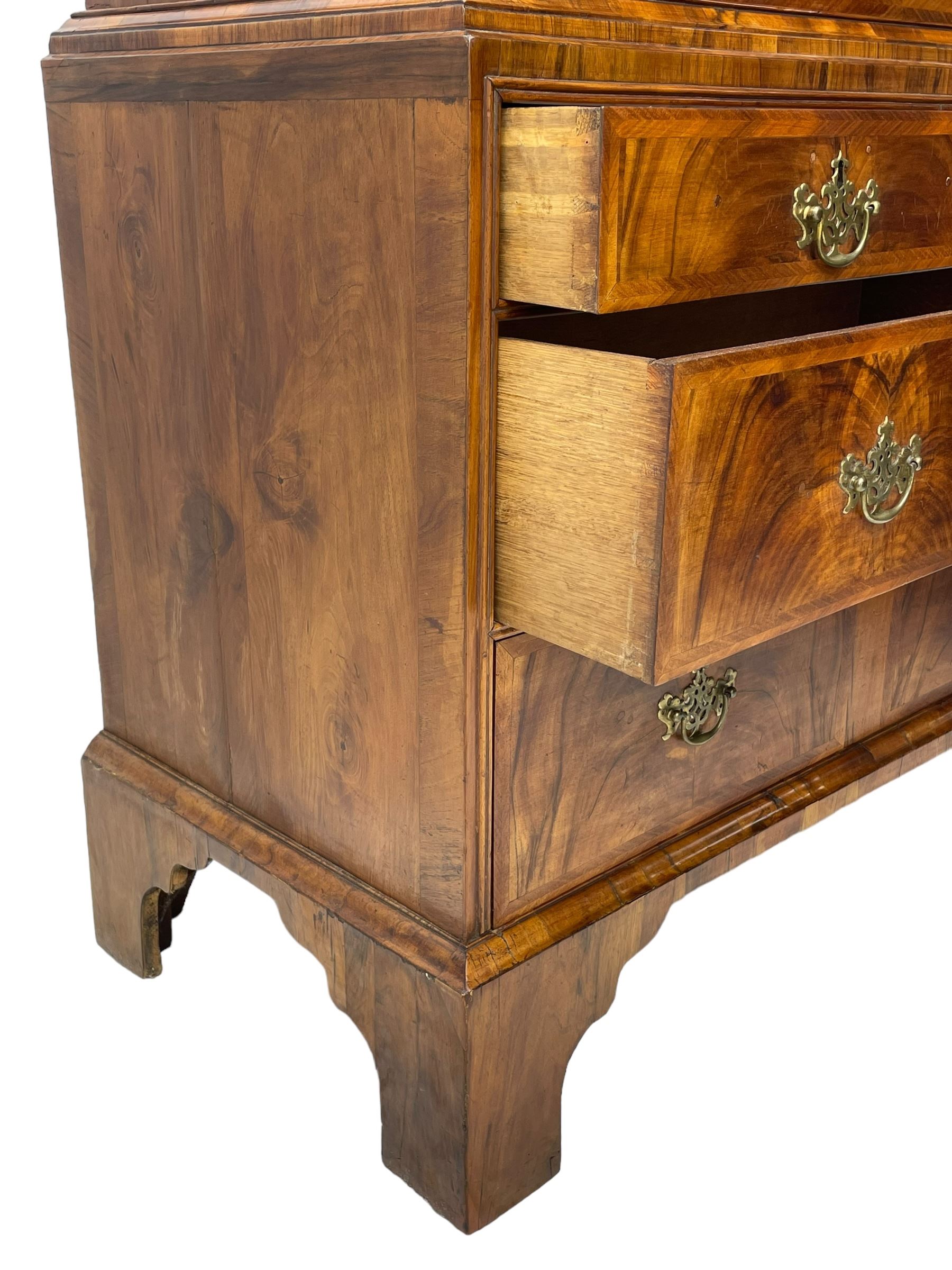 Early 18th century William & Mary figured walnut escritoire, projecting moulded cornice over shallow frieze drawer, the figured fall front enclosing interior fitted with small drawers, cupboards, pigeon holes and hidden drawers, the lower section fitted with two short and two long graduating drawers, on tall bracket feet 