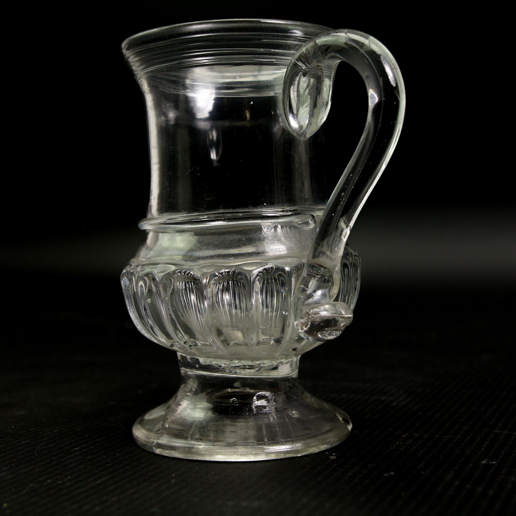 Glass coin jug, with ribbed body and inset with a George II silver 1d penny, H11cm; an 18th century Shrub decanter, circa 1785, H15.5cm; together with an 18th century English green wine bottle, H29.5cm (3)