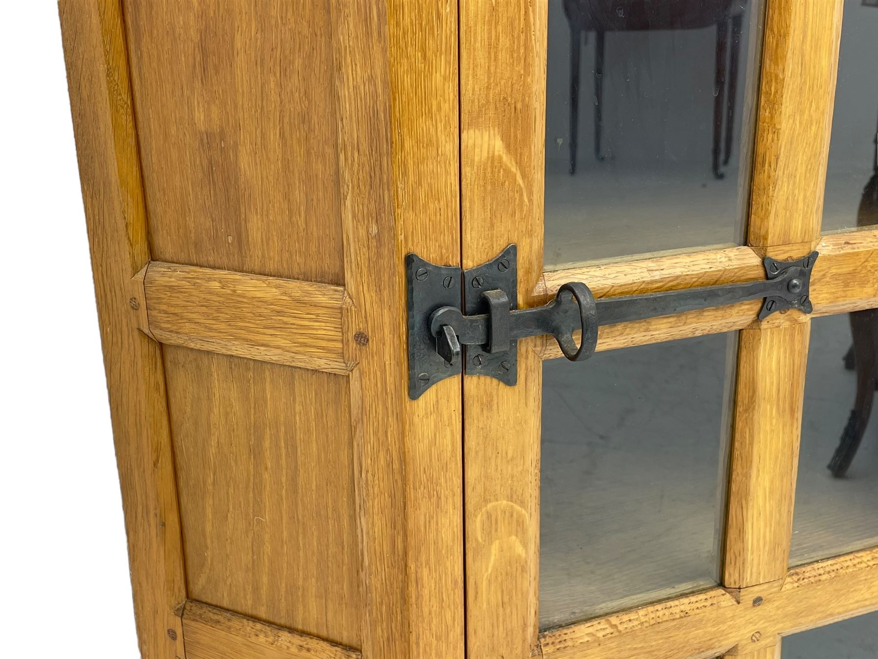 Rabbitman - oak corner cabinet, astragal glazed door enclosing three internal shelves, panelled upright corners, fitted with wrought metal hinges and latch, carved with rabbit signature, by Peter Heap, Wetwang 