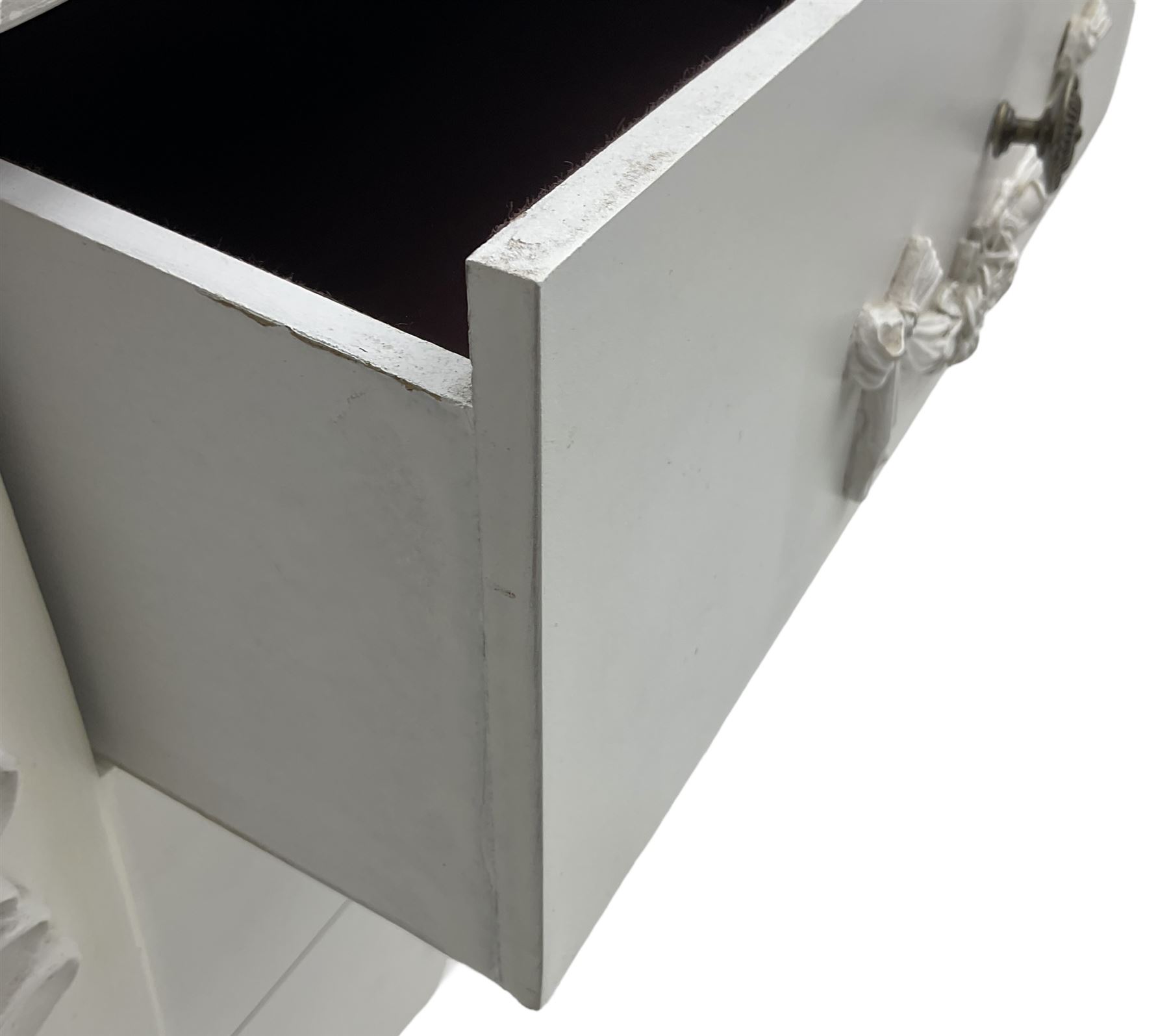 French design white painted chest, shaped top over three drawers, each with applied swags with flower heads, flanked by cabriole uprights with foliate mouldings