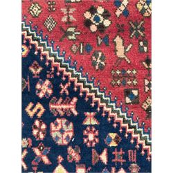 South West Persian Abadeh crimson ground rug, indigo ground with crimson lozenge field, decorated all over with small stylised motifs of flowerheads, hooks, animals and birds, guarded border decorated with trailing leaves and stylised plant motifs 