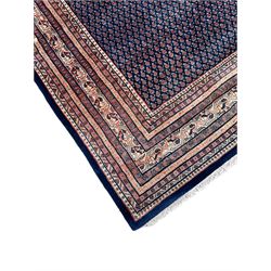 Large North-West Persian Arrak indigo ground carpet, the field decorated all-over with small Boteh motifs, multiple band border decorated with repeating geometric designs