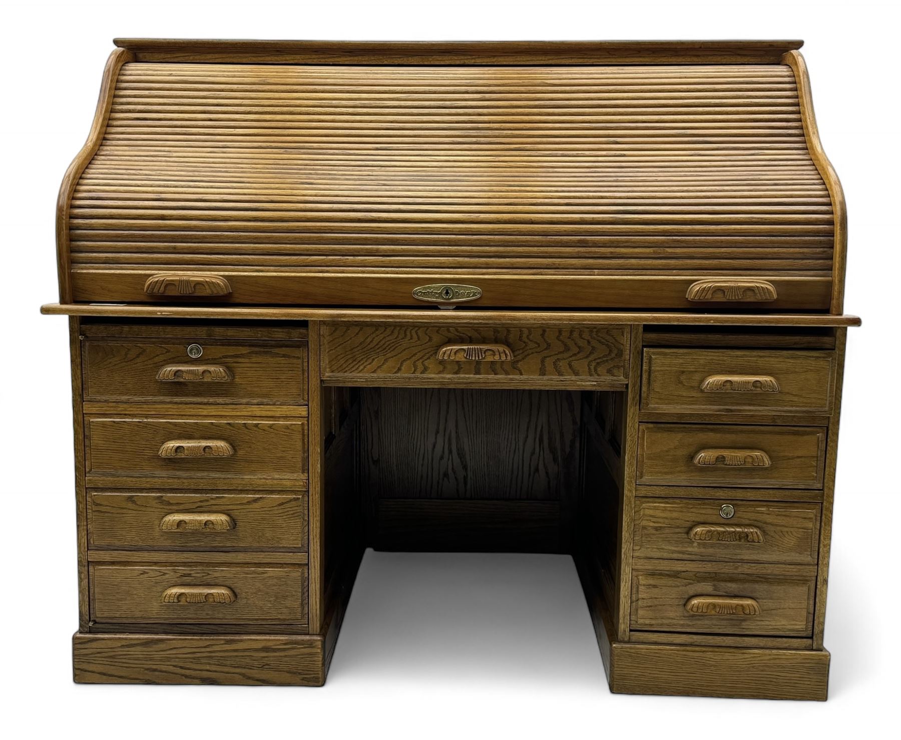 Early 20th century oak tambour roll-top desk, the top with fitted interior including drawers, pigeonholes and compartments, the twin pedestals fitted with four drawers with carved handles, supported by plinth base 