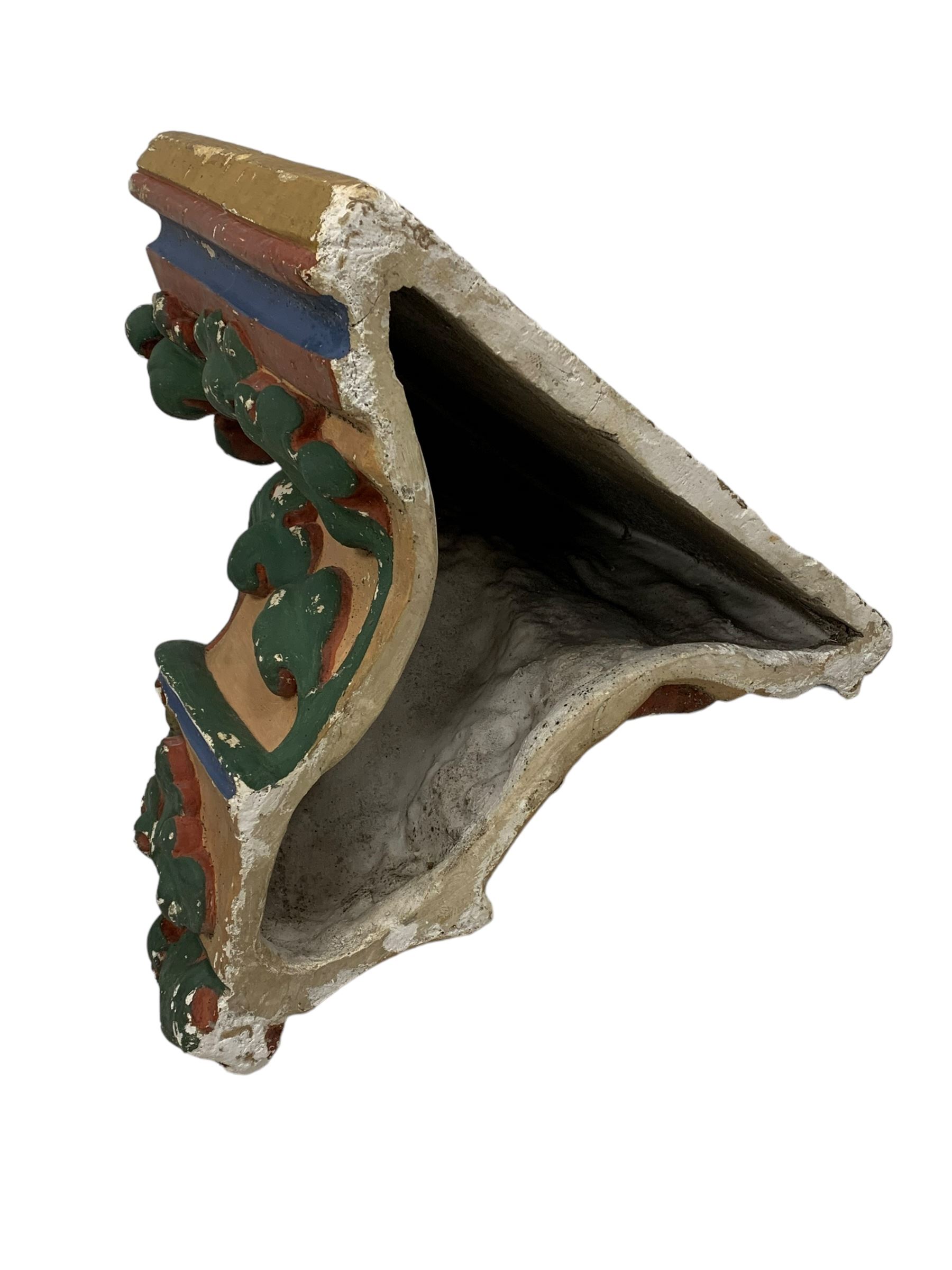 Two Victorian polychromed plaster cast corbels or wall brackets, canted rectangular tops over moulded edge and curled fruiting foliage