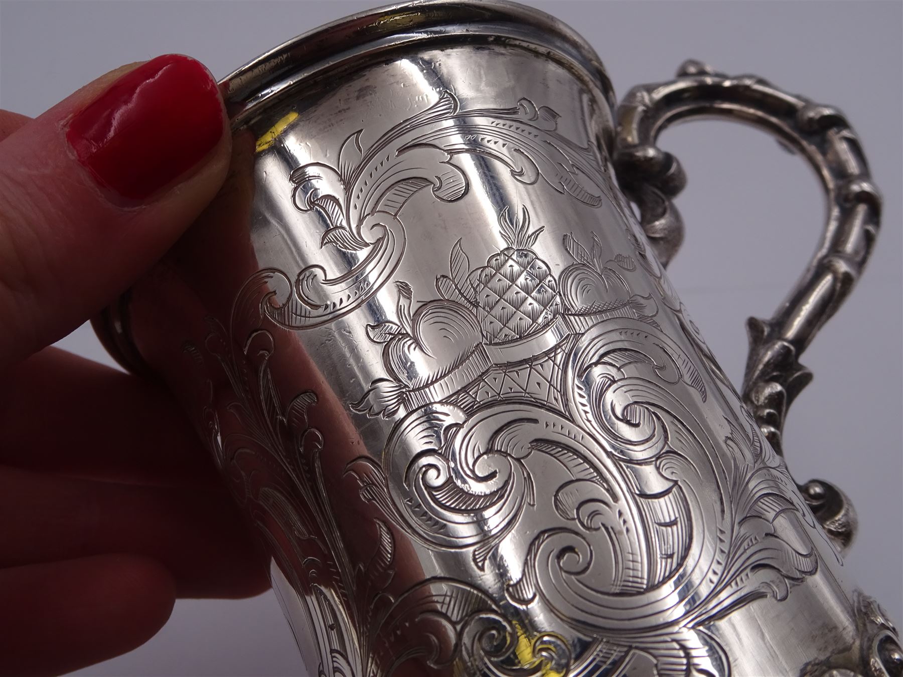 Victorian silver christening mug, of cylindrical form with fluted rim, gilt interior and acanthus capped C scroll handle, the body with later engraved decoration and initials, with embossed scroll base, hallmarked John Evans II, London 1840, including handle H10.2cm