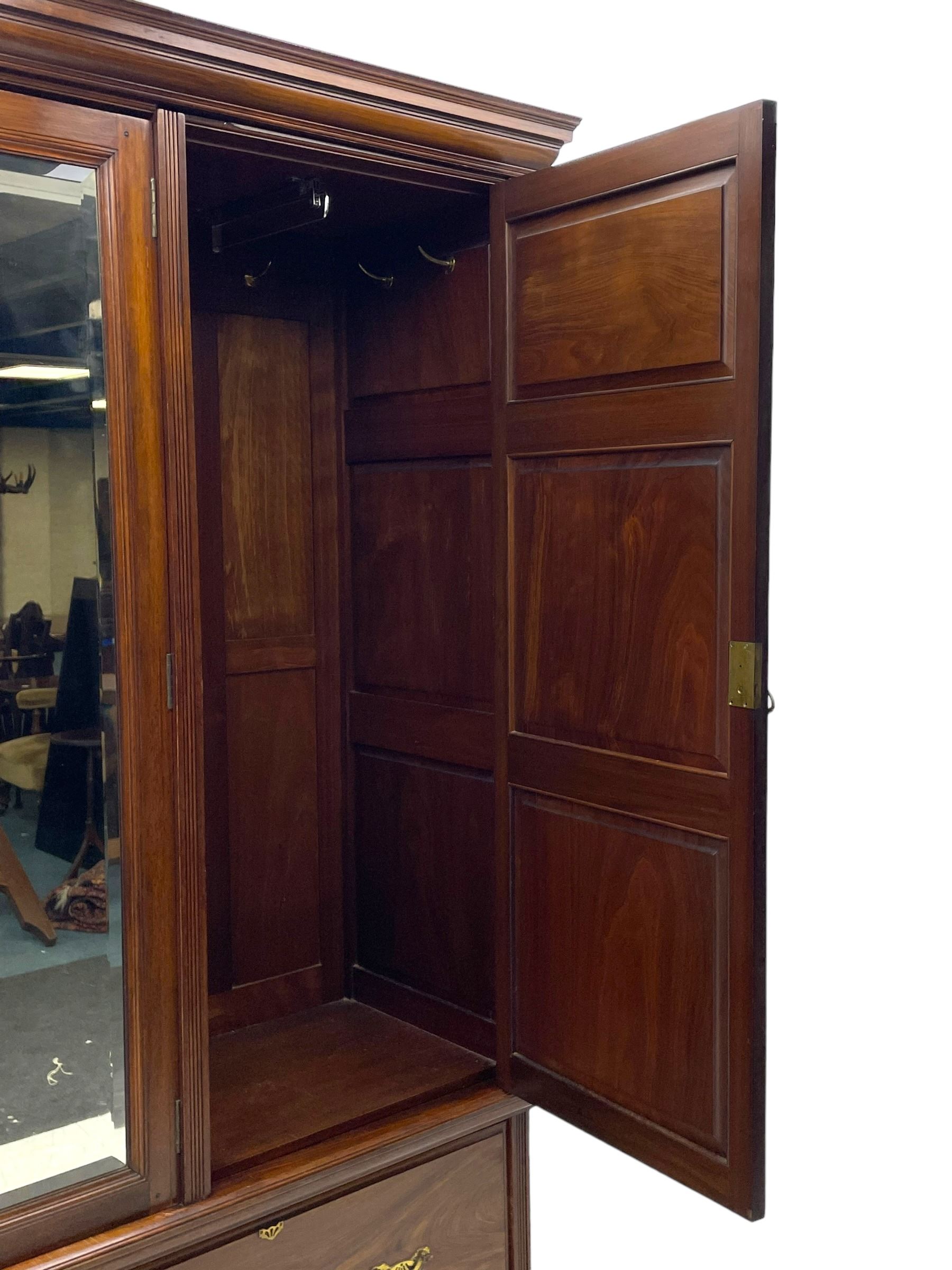 Late Victorian walnut triple wardrobe, projecting moulded cornice over central bevelled mirror door and flanking panelled doors, the top panels carved with fluted fans and stylised leaf motifs, the interior fitted with three linen slides, two drawers and hanging space, two long drawers to base, reed moulded uprights and vertical fluted horizontal rails 