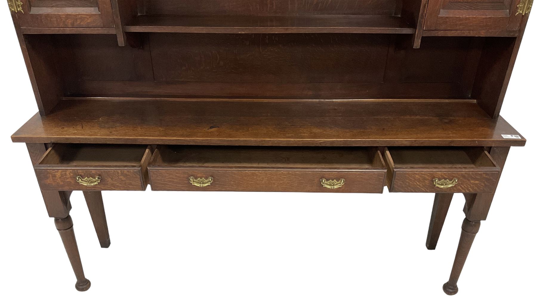 Early 20th century Georgian design oak dresser, projecting cornice with shaped apron over a three-tier plate rack with flanking fielded spice cupboards, the base fitted with three drawers, on turned supports