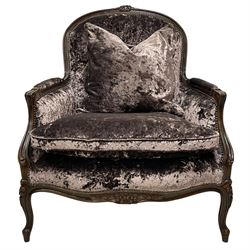 French design walnut framed wide-seat armchair, moulded frame carved with flowers, upholstered in purple crushed velvet, the lower rail carved with flowers and extending foliage, on cabriole feet