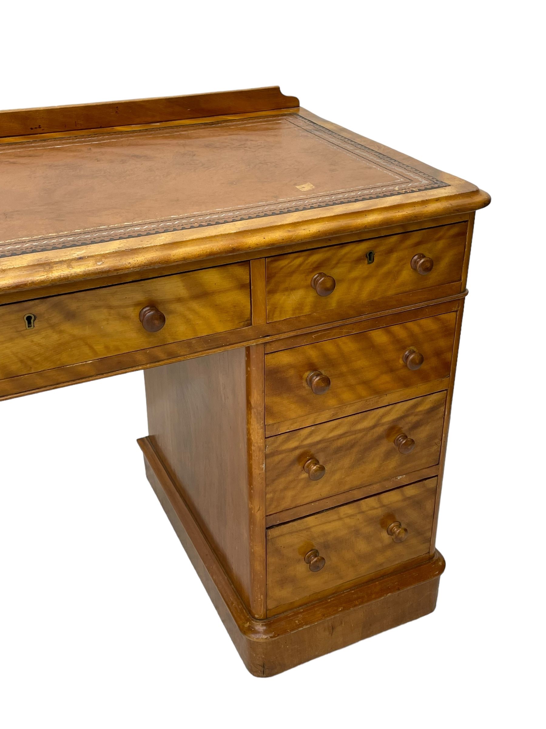 Victorian satin walnut twin pedestal desk, moulded rectangular top with rounded corners and raised back, inset leather writing surface with tooled borders, fitted with nine drawers with turned handles, on moulded plinth base 