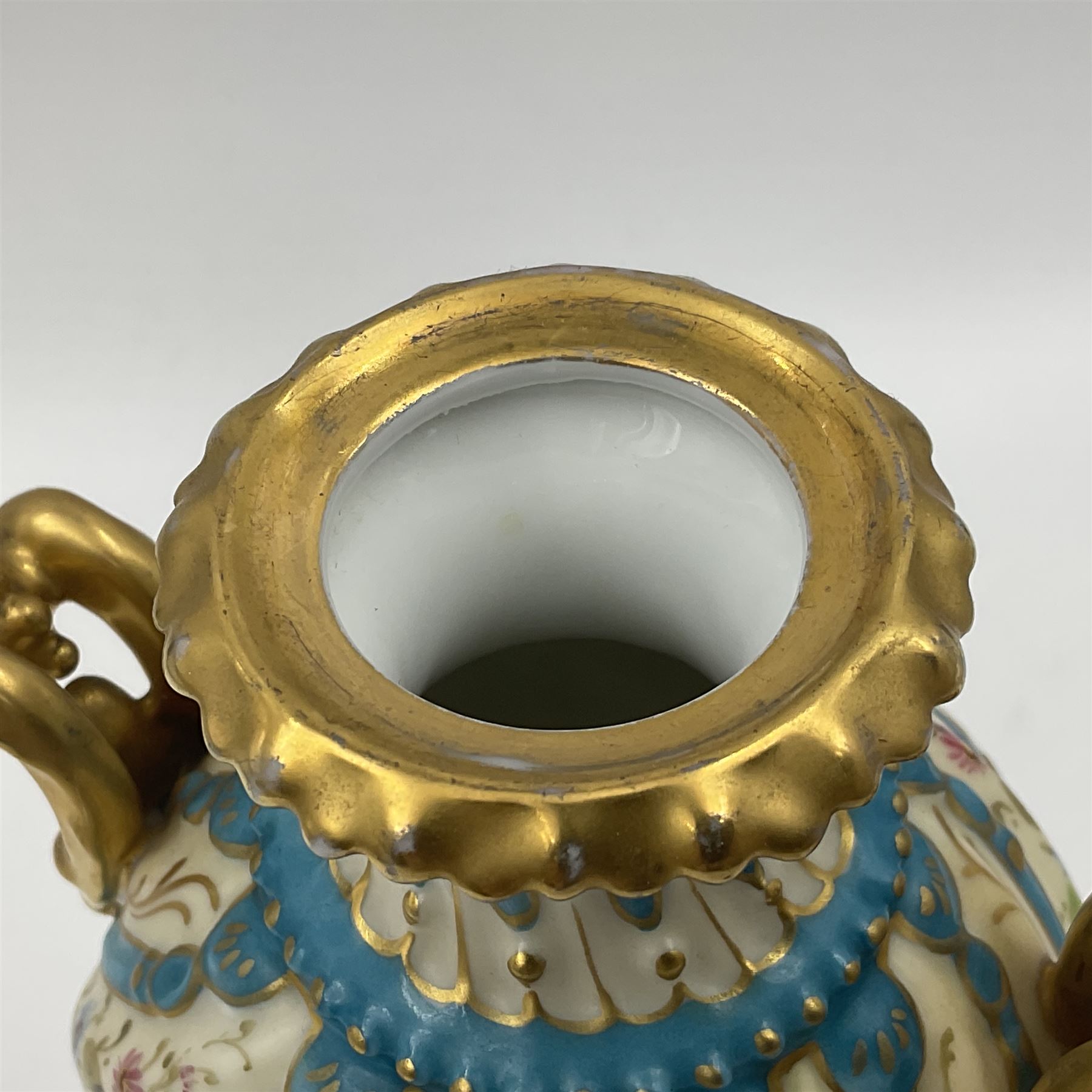 Pair of late 19th/early 20th century Sevres style vases and covers, of baluster form with gilt scroll handles and domed covers, the wrythen fluted bodies decorated with alternating bands of painted fruit and flowers and gilt vines, upon a white and celeste blue ground, with printed and impressed marks beneath, H22.5cm 