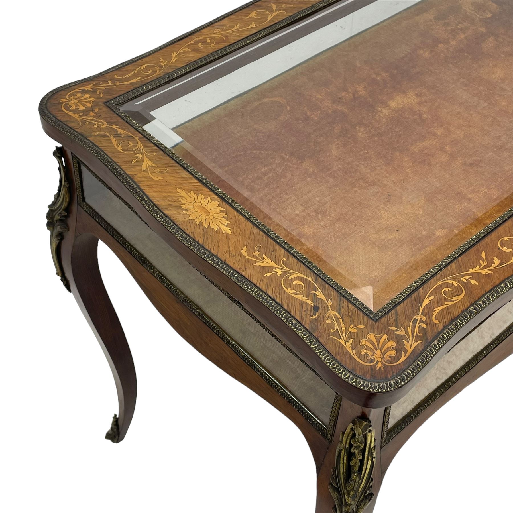 Victorian inlaid rosewood bijouterie table cabinet, shaped form, enclosed by hinged bevel glazed lid with shell and floral inlays, fabric lined interior, glazed sides within foliate cast gilt metal edging, on cabriole supports with floral cast gilt metal mounts and terminal caps 