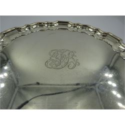 Early 20th century silver waiter, of circular form with pie crust rim, engraved with monogram to centre, upon three foliate feet, hallmarked Thomas Bradbury & Sons Ltd, London 1911, D15.5cm