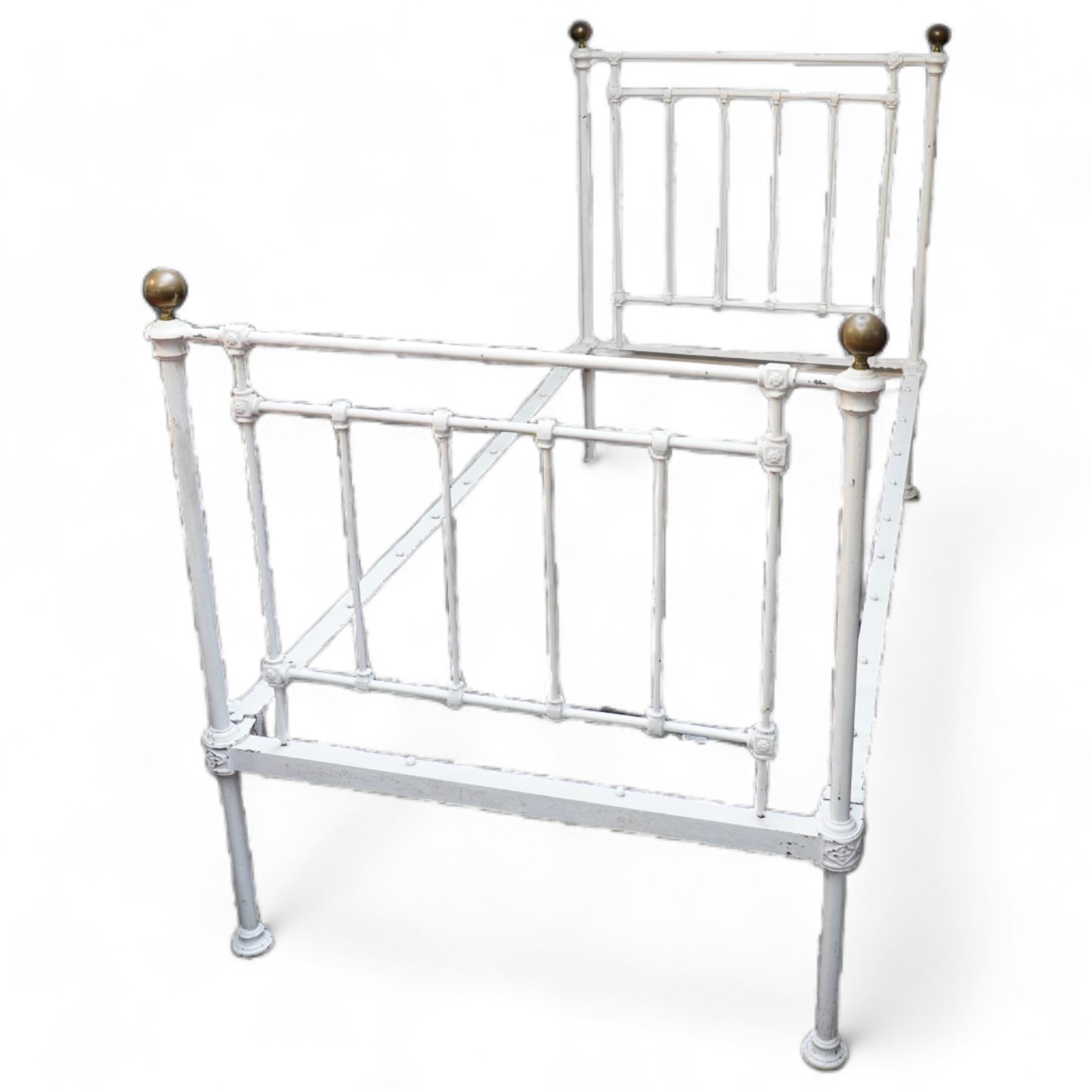 Victorian white painted cast iron 3' single bedstead, brass finials over floral moulded spindles, on castors