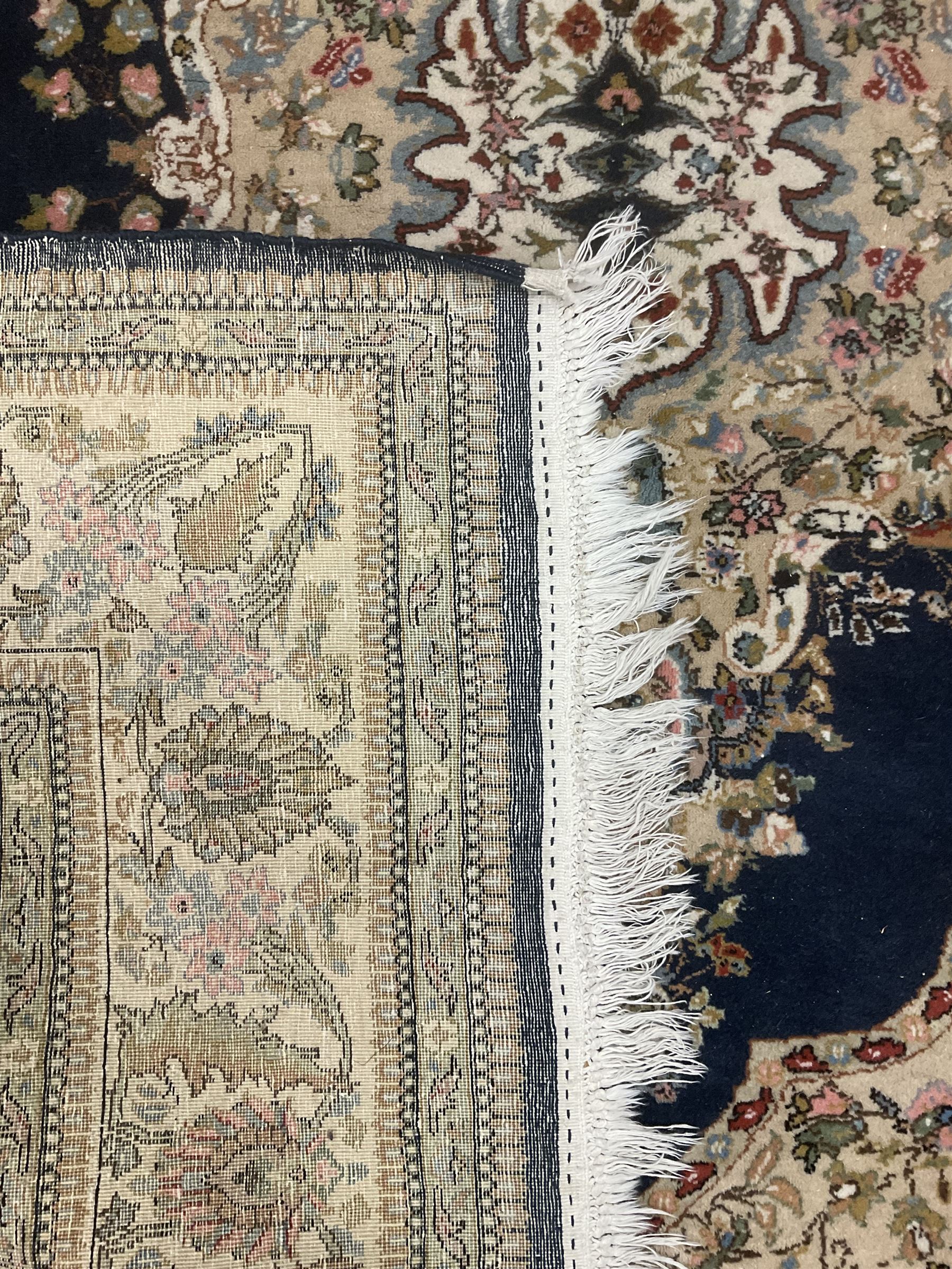 Persian Kirman indigo ground rug, central floral design medallion with matching spandrels, the guarded border decorated with stylised plant motifs 