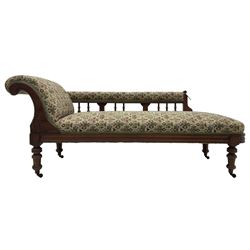 Late 19th century walnut framed chaise longue, upholstered in floral pattern fabric, rolled back rest and turned balustrade back, on turned feet with brass and ceramic castors 