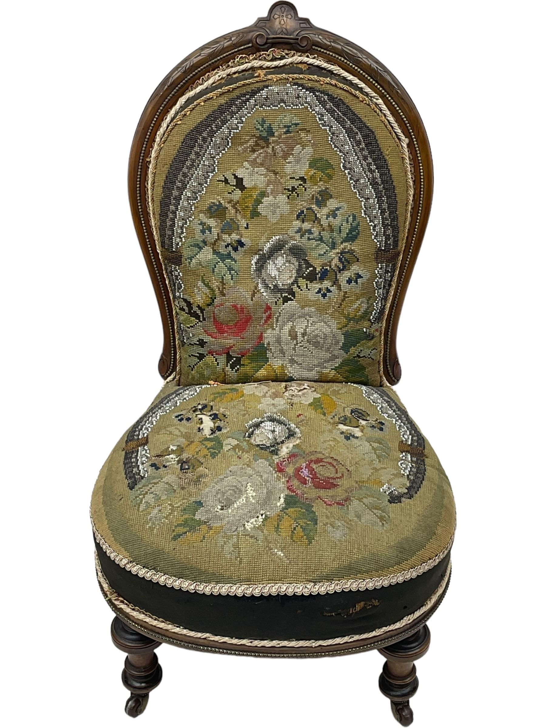 Early 20th century mahogany side chair, detailed marquetry frame, backrest with central urn motif and scrollwork inlay, arched crest rail with floral designs, cream and gold patterned fabric seat, turned front legs with brass castors (H78cm); Victorian walnut nursing chair, carved crest rail, floral needlepoint tapestry upholstery, turned front legs with ceramic castors (H81cm)