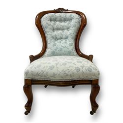 Victorian walnut nursing chair, the curved cresting rail carved with central cartouche and scroll leaves, upholstered in pale blue fabric decorated with trailing floral design, on cabriole front feet 