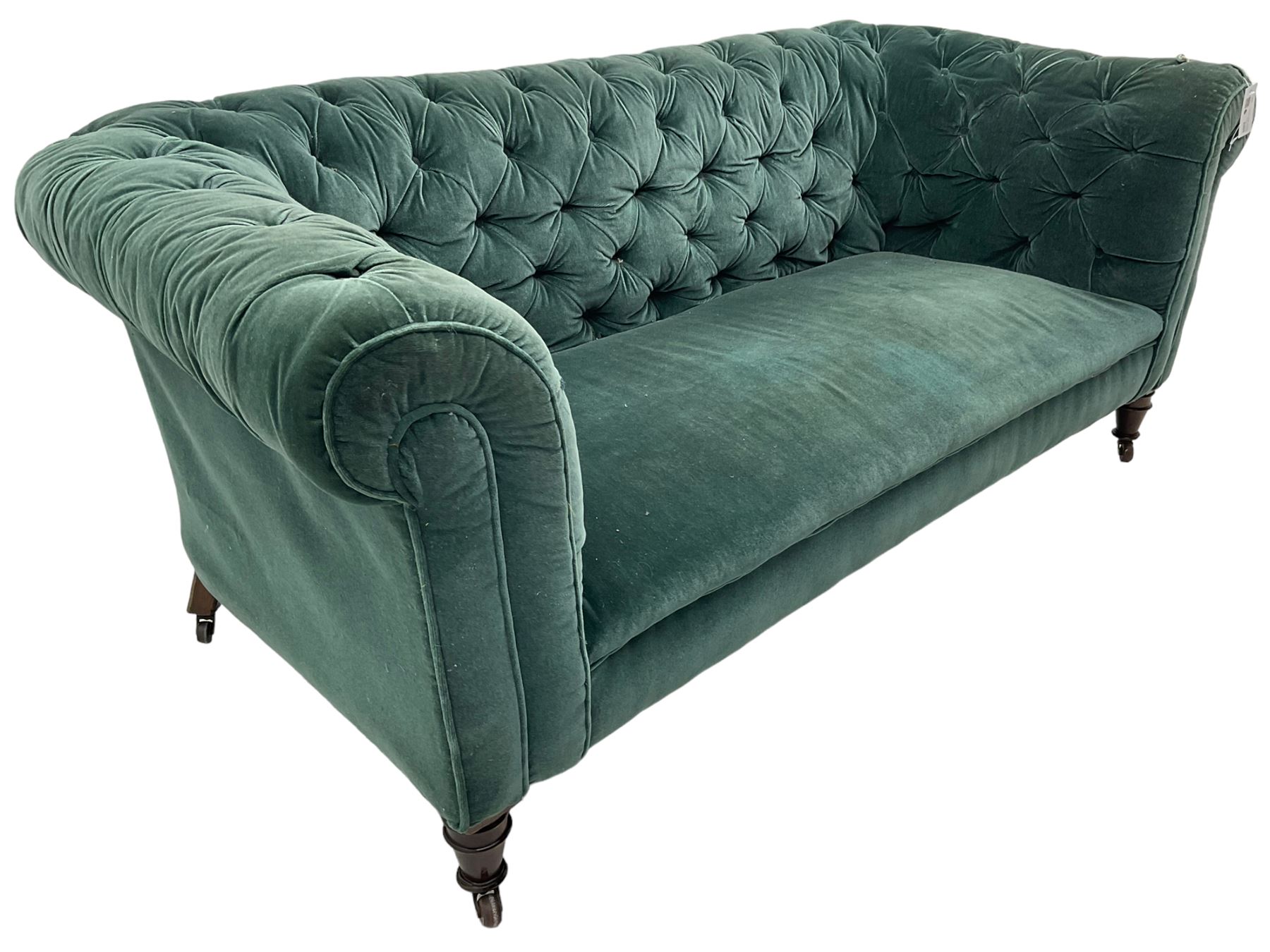 Victorian hardwood-framed Chesterfield sofa, traditional shape with low back and rolled arms, upholstered in teal buttoned fabric, on turned front feet with brass and ceramic castors 