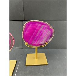 Pair of pink agate slices, polished with rough edges, raised upon gilt metal stands, H20cm