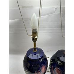 Pair of Moorcroft table lamps, in Anemone patter, upon a blue ground, with cream lampshades, H68