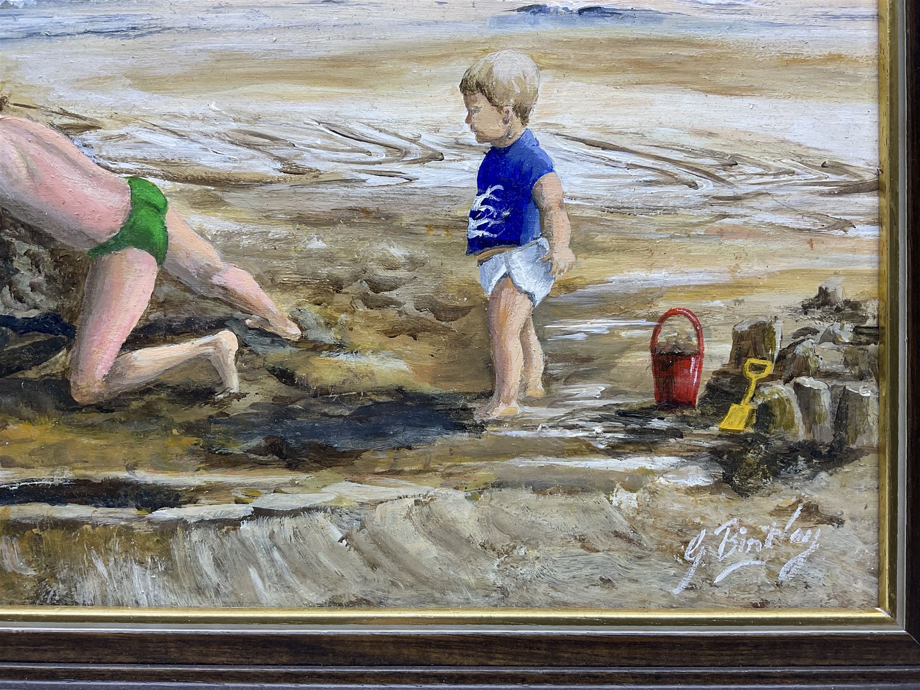 Glenys Bintley (Northern British 20th Century): Children Building a Sandcastle, oil on board signed, artists address label verso 34cm x 64cm