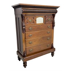 Late Victorian walnut Scotch chest, projecting cornice with turned quarter column mounts over matching half column to frieze, fitted with two upper short drawers with central cupboard, bevelled mirror glazed cupboard door, four graduating drawers below, foliage and flower head carved brackets to the uprights, panelled sides, chamfered plinth on turned feet