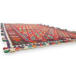 Southwest Persian Qashqai Kilim crimson ground rug, decorated with a repeating geometric pattern of interlocking diamond motifs in red, green, blue, and brown, enclosed by a deep brown border with stylised floral motifs and colourful fringe accents