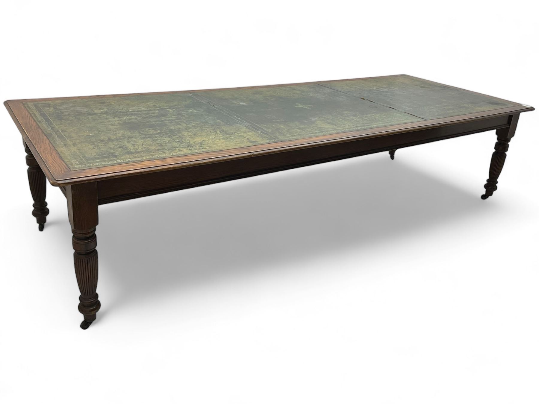 Large 10' 7'' late Victorian oak boardroom table, moulded rectangular top with inset green leather surface, on turned and reed moulded supports with brass and ceramic castors 