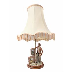 Capodimonte figural table lamp, modelled as an artist showcasing his work, with fabric tas...