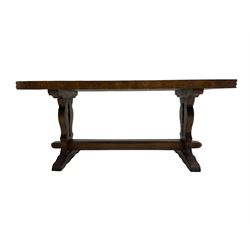 Solid oak coffee table, rectangular waved cut top with tooled ends, on shaped and pierced end supports joined by pegged stretcher 