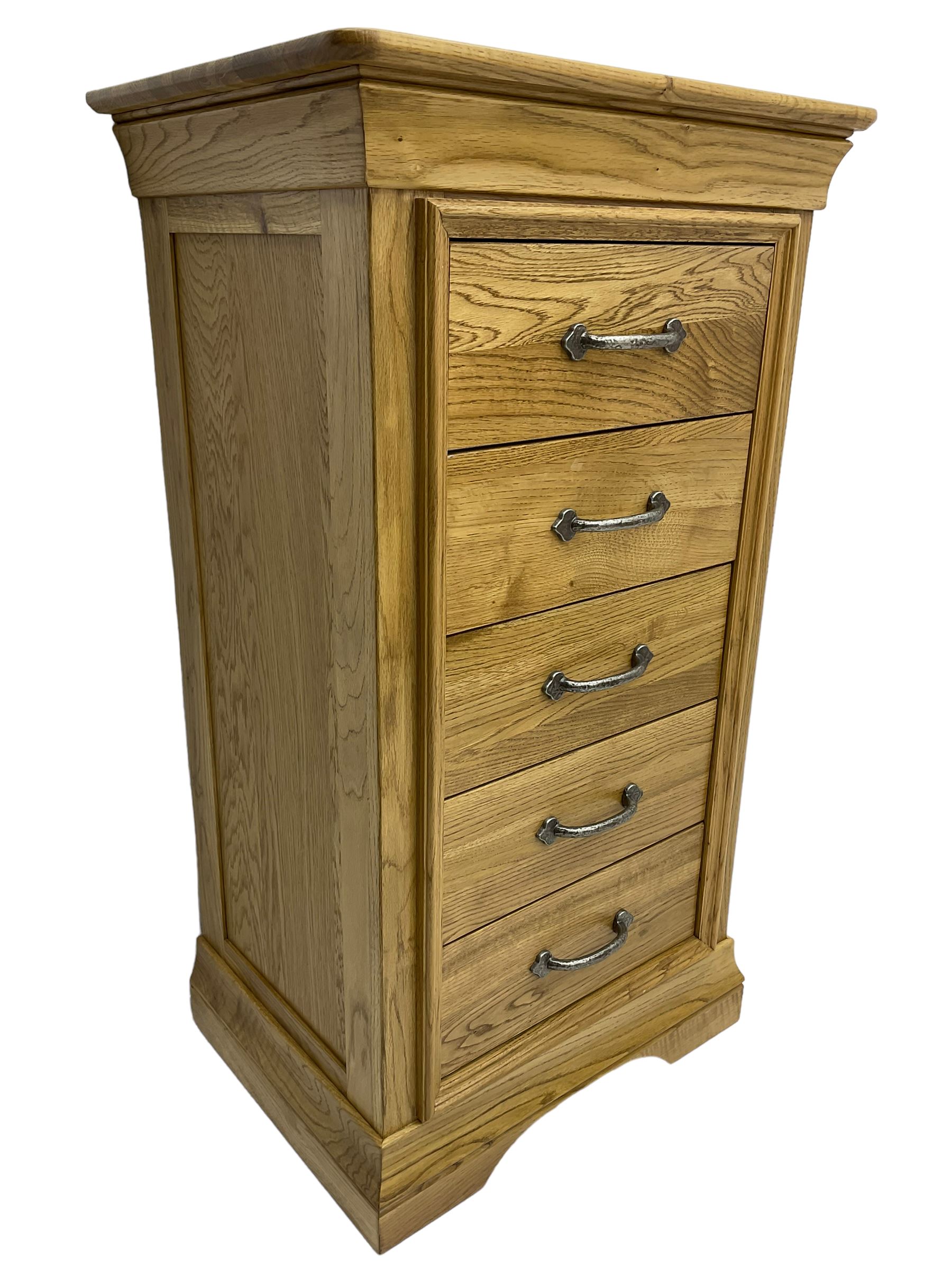 Contemporary light oak pedestal chest, moulded cornice and chamfered rectangular top with rounded fronts, over five drawers with metal handles and cock-beaded surrounds, on bracketed plinth base