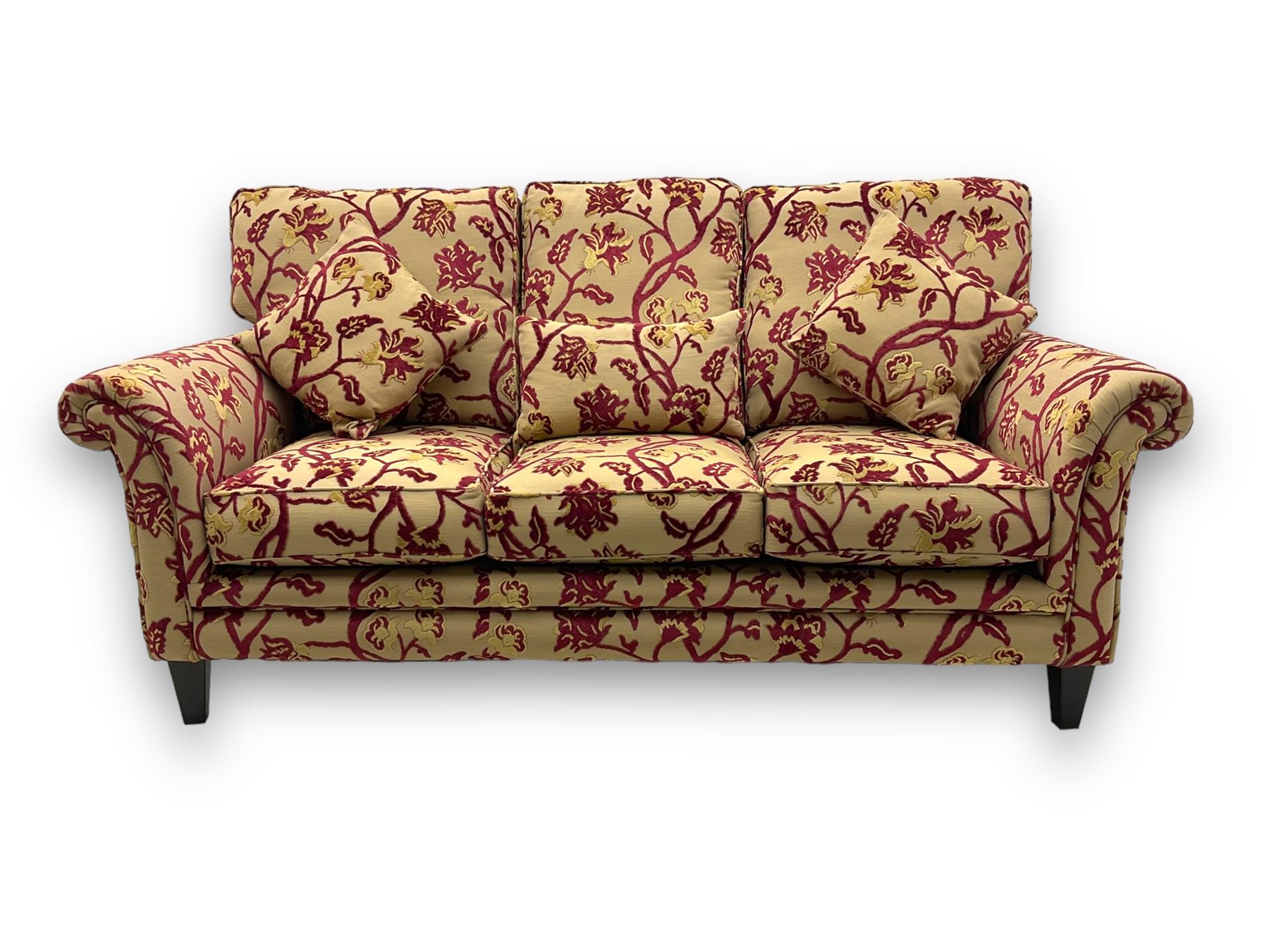 Contemporary upholstered three-seat sofa, scroll arms and loose cushions, embossed beige ground fabric with red and gold floral motifs, on tapered wooden supports