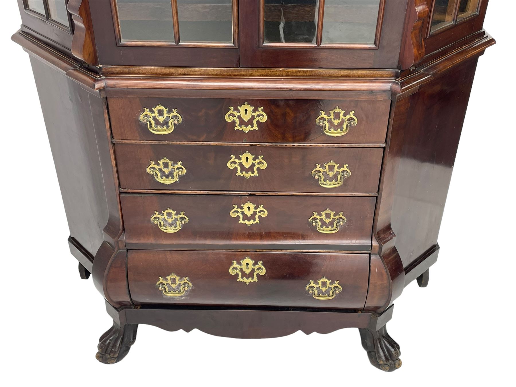 19th century Dutch mahogany vitrine on chest, shaped moulded pediment with central C-scroll and flowerhead carved mount, enclosed by two astragal glazed doors, the interior fitted with fabric lined shelves, four graduating long drawers below, on ball and claw carved feet 