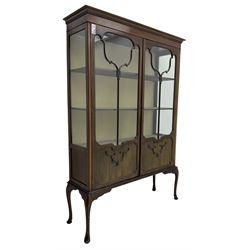 Early 20th century mahogany straight-front display cabinet, projecting moulded cornice over two astragal glazed doors with lower panels, on cabriole supports 