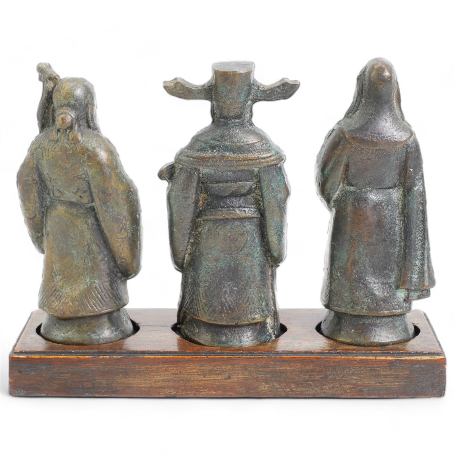 Set of three Chinese bronze deities, on a rectangular hardwood stand, L13cm