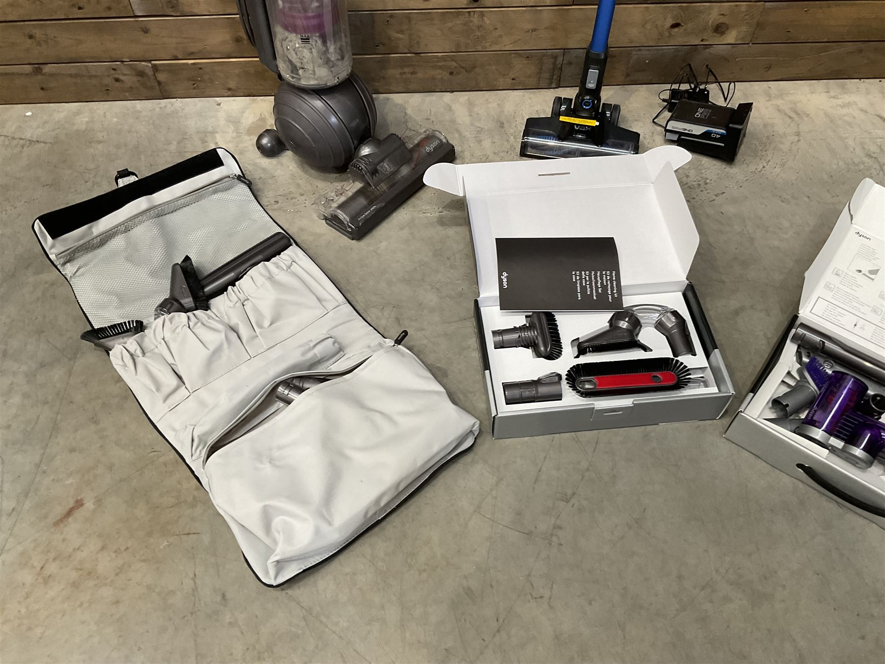 Dyson DC40 vacuum cleaner with various attachments, and a Vax cordless vacuum cleaner with single battery and charger