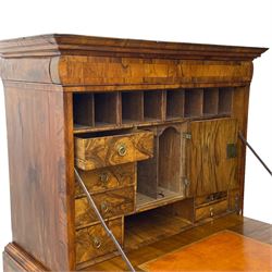 Early 18th century William & Mary figured walnut escritoire, projecting moulded cornice over shallow frieze drawer, the figured fall front enclosing interior fitted with small drawers, cupboards, pigeon holes and hidden drawers, the lower section fitted with two short and two long graduating drawers, on tall bracket feet 