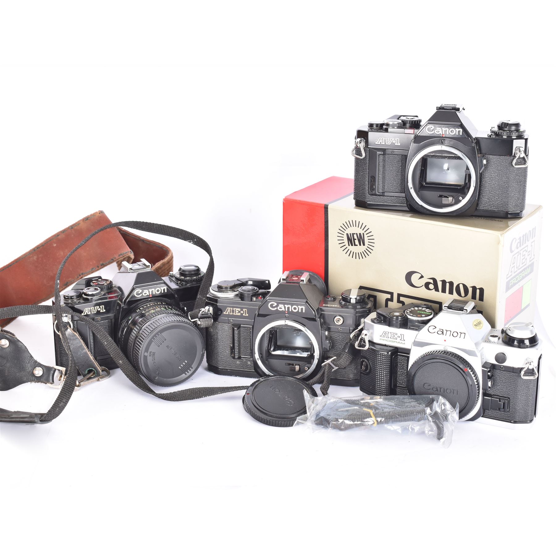 Four Canon SLR camera bodies, to include AE-1 Program, in black and silver finish, serial no. 4330401, boxed, AE-1 serial no. 1234206 and two AV-1 examples, serial nos. 841957 & 334882, one with a Canon FD 50mm 1:18 lens